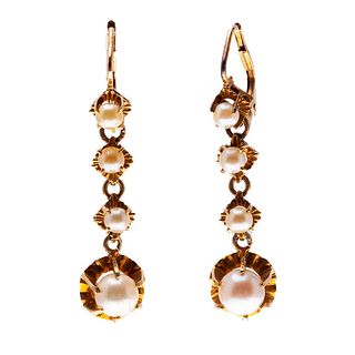 Par de aretes con perlas en oro amarillo de 14k. 8 perlas cultivadas color crema de 2 y 5 mm. Peso: 4.7 g.