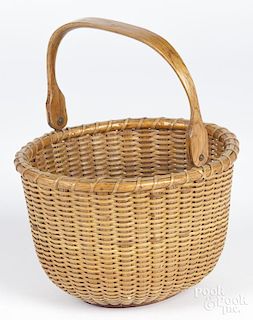 Nantucket lightship basket, mid 20th c., the underside with a branded crescent, 5'' h., 7'' w.
