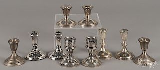 Five pairs of weighted sterling silver candlesticks.