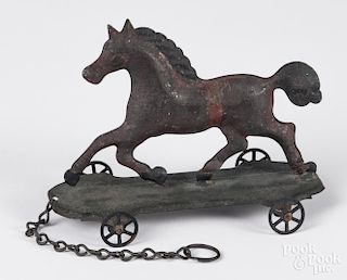 American painted tin horse platform pull toy, the base stamped New York, 6'' l.