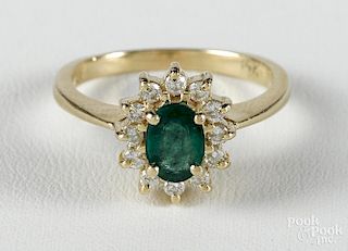 14K yellow gold ring with an oval cut emerald surrounded by twelve full cut diamonds, size 7.5