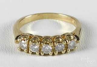 Gold and diamond ring with a 14K yellow gold band with five round, brilliant cut diamonds