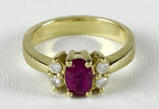 18K yellow gold ring with a central oval cut ruby flanked by four full cut diamonds, size 6.5