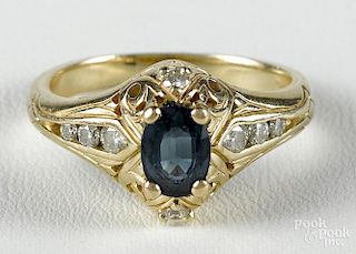 14K yellow gold and sapphire ring with an oval pale blue sapphire flanked by eight accent diamonds