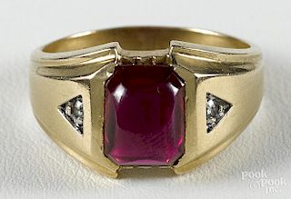 14K yellow gold ring with a central synthetic ruby cabochon flanked by two small diamond accents