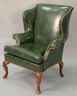 Leather upholstered Queen Anne style wing chair.