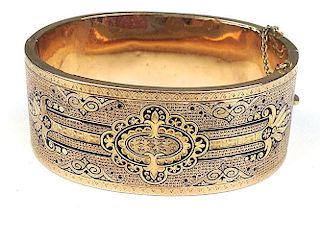 unmarked yellow gold Victorian bracelet with Aesthetic Movement decoration and contrasting black enamel 1" wide hollow band, 2.5" oval dia.