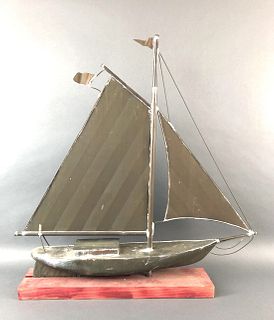 A Copper Sail Boat On A Wooden Base
