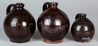 Three Pennsylvania redware jugs, 19th c., tallest