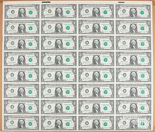Seven uncut sheets and sections of US currency.