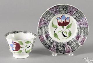 Black and purple rainbow spatter cup and saucer, 19th c., with tulip decoration.