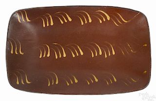 New England redware loaf dish, 19th c., with yellow slip decoration, 10'' h., 16'' w.