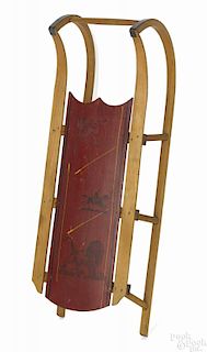 Painted sled, late 19th c., retaining its original red surface with a stenciled lion and a horse