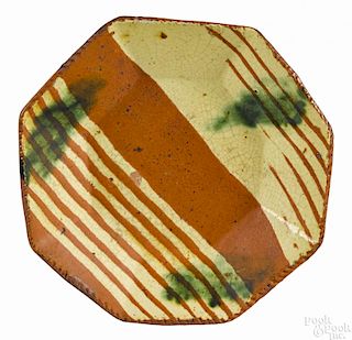 Octagonal redware plate, 19th c., with yellow slip and green splashes, 6'' dia.