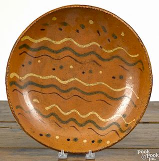 Pennsylvania redware charger, 19th c., with yellow, green, and brown slip decoration, 11 7/8'' dia.