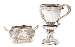 * Two German Silver Table Articles, , the first a handled cup raised on pedestal, having a foliate border and vacant emblematic