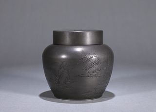 An inscribed landscape patterned tin jar