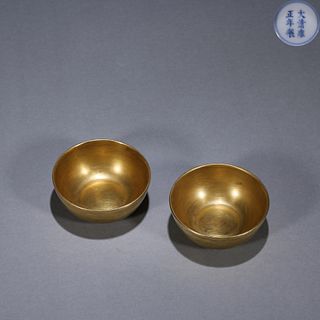 A pair of gilt porcelain cups
