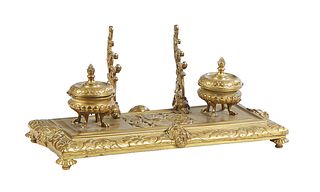 Victorian Bronze Inkstand, 19th c., with a pierced relief floral center, in front of a pen tray and flanked by two covered inkwells, on bronze disc fe
