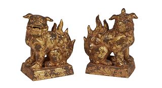 Pair of Heavy Cast Iron Foo Dogs, early 20th c., on an integral relief decorated sloping rectangular base, in gilt paint, H.- 7 1/2 in., W.- 6 1/4 in.