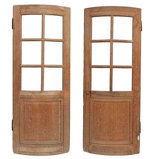Unusual Pair of French Curved Pine Doors, late 19th c., each with eight glazed panels over a curved lower fielded wood panel , the glass now removed, 