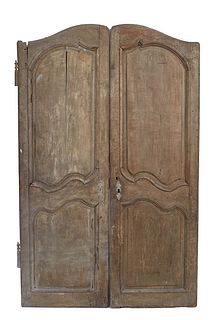 Pair of French Provincial Carved Walnut Armoire Doors, 19th c., with double arched fielded panels, each H.- 71 in., W.- 22 in., D.- 1 in. Provenance: 