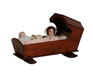French Provincial Carved Pine Rocking Cradle, 19th c., together with a 20th c. baby doll with sleep eyes, H.- 25 in., W.- 39 in., D.- 24 1/2 in.