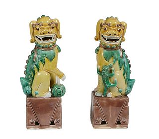 Pair of Chinese Polychromed Earthenware Foo Dogs, 20th c., on an integral rectangular base, H.- 11 in., W.- 3 1/2 in., D.- 2 3/4 in.