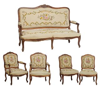Five Piece French Carved Walnut Louis XV Style Parlor Suite, 20th c., consisting of two fauteuils, two side chairs, and a settee, with arched canted f