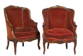 Pair of French Louis XV Style Carved Walnut Bergeres, early 20th c.,the floral carved arched crest rail over an upholstered back, wings and scrolled a