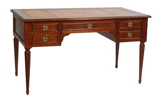 French Louis XVI Style Carved Walnut Desk, early 20th c., the ogee edge stepped top with an inset gilt tooled salmon colored leather writing surface, 