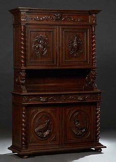 French Provincial Henri II Style Carved Oak Buffet a Deux Corps, c. 1880, the breakfront top over setback cupboard doors with relief carved hunting mo
