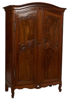 Diminutive French Provincial Carved Walnut Louis XV Style Armoire, 19th c., the stepped arched crown over double three panel doors with iron escutcheo