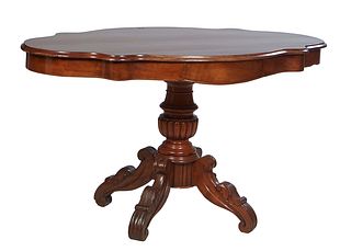 French Carved Walnut Center Table, c. 1870, the stepped tortoise top over a wide skirt with a center drawer on one long side, on a turned tapered reed