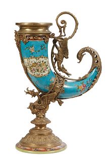 Bronze Mounted Porcelain Cornucopia Vase, 20th c., in heavenly blue with floral decoration, with a winged gryphon handle, on a winged dragon socle sup