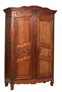 Monumental French Provincial Louis XV Style Carved Walnut Armoire, c. 1820, the arched stepped crown with a central leaf and vine carved applique, ove