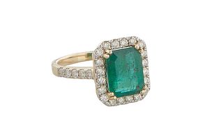 Lady's 14K Yellow Gold Dinner Ring, with a 3.02 carat emerald within an octagonal border of small round diamonds, the shoulders of the band also mount