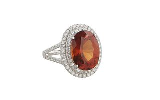 Lady's 18K White Gold Dinner Ring, with a 8.11 carat oval spessartite garnet atop a double concentric graduated border of round diamonds, the split sh