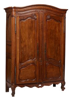 French Provincial Carved Walnut Louis XV Style Armoire, early 19th c., the stepped arched crown over double two panel doors with large iron fiche hing