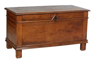 French Provincial Carved Walnut Coffer, 19th c., the lifting lid over a front panel with applied molding and a horizontal brass escutcheon, on a plint