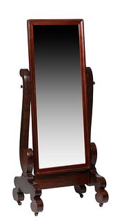 American Classical Carved Mahogany Cheval Mirror, late 19th c., the wide frame around a wide beveled mirror, on scrolled supports to scrolled trestle 