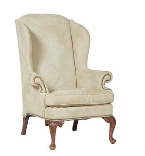 English Carved Mahogany Queen Anne Style Wing Chair, 20th c., the arched wing back over rolled upholstered arms and a bowed removable cushion seat, on