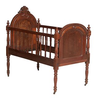 American Victorian Carved Burled Walnut Child's Crib, c. 1880, the arched scrolled crest headboard flanked by turned posts, to wooden spindled rails, 