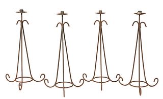 Group of Four Wrought Iron Candlesticks, 20th c., the iron candle cup and bobeche, on a tapering scrolled tripodal support, joined by a lower circular