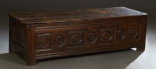 French Provincial Carved Oak Coffer, 19th c., the rounded corner lid over a front with seven relief carved panels, on block feet, H.- 21 in., W.- 69 1