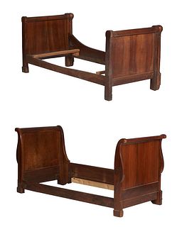 Two French Louis Philippe Carved Walnut Lit Du Coin Beds, 19th c., one of sleigh form with a curved headboard and footboard joined by a large wooden f