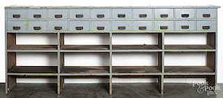 Large painted country store counter, ca. 1900, with two rows of ten drawers, over shelves