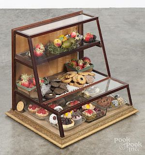 Country store wooden counter top showcase, ca. 1900, filled with miscellaneous faux cookies