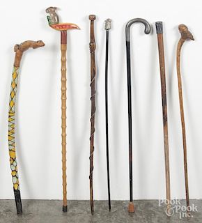 Seven walking sticks, to include several carved folk art examples.
