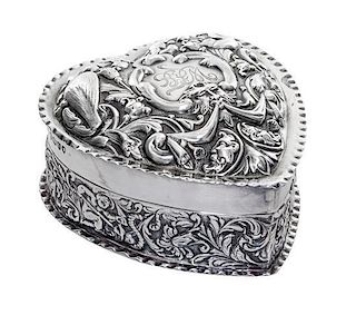 A Victorian Silver Covered Box, William Comyns, London, 1889, in the form of a heart, the lid worked with mask, bird and C-scrol